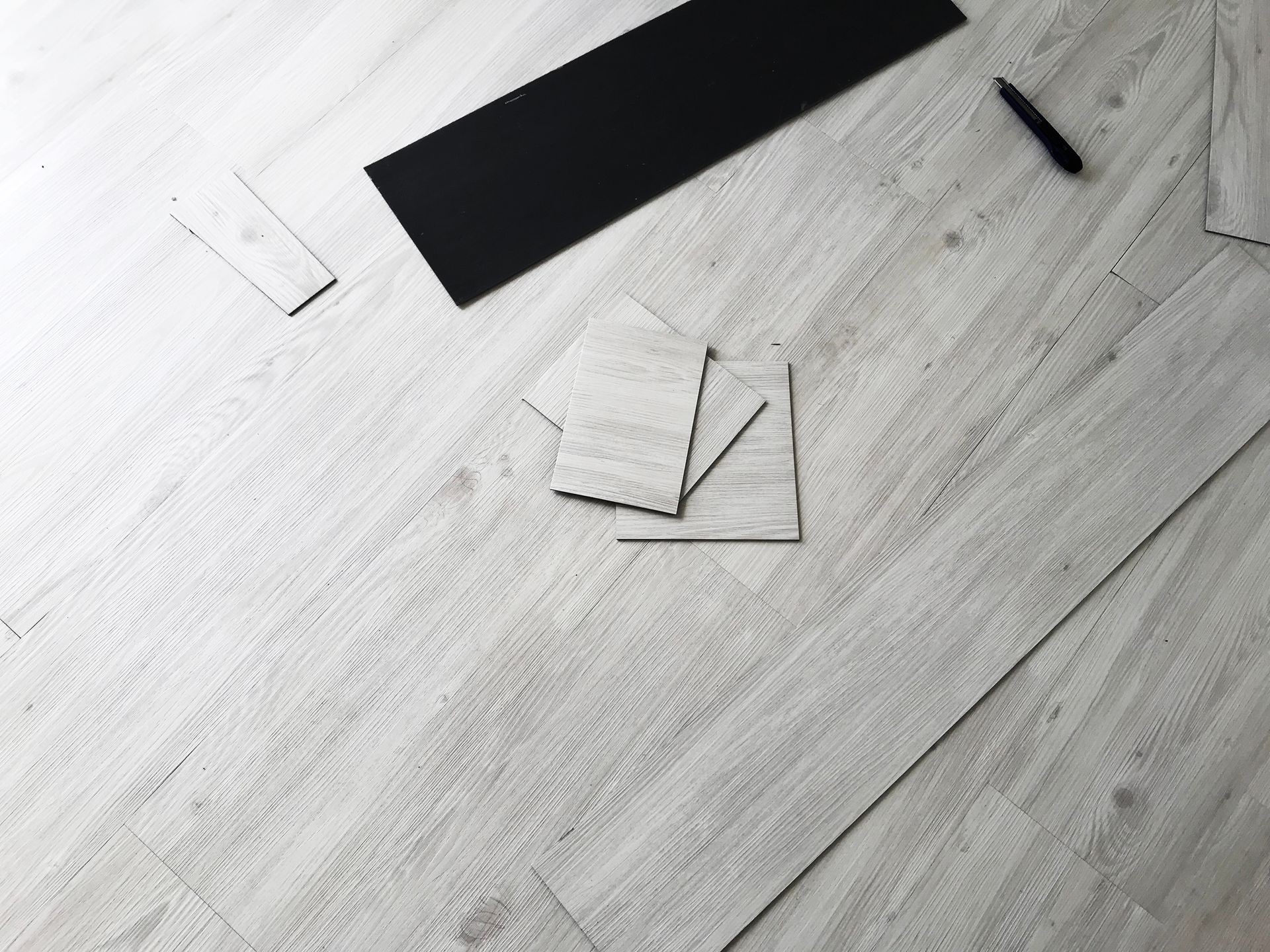 Home renovate. Renovate home floor with glue on base during parquet wood flooring. White Wood vinyl laminate Flooring Installation on parquet background. Material for sweet home.